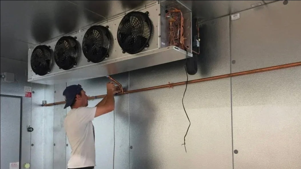 On-site work at a walk-in cooler evaporator and refrigerant piping.